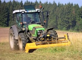 Traktor mit Mulchgerät beim Mulchvorgang
